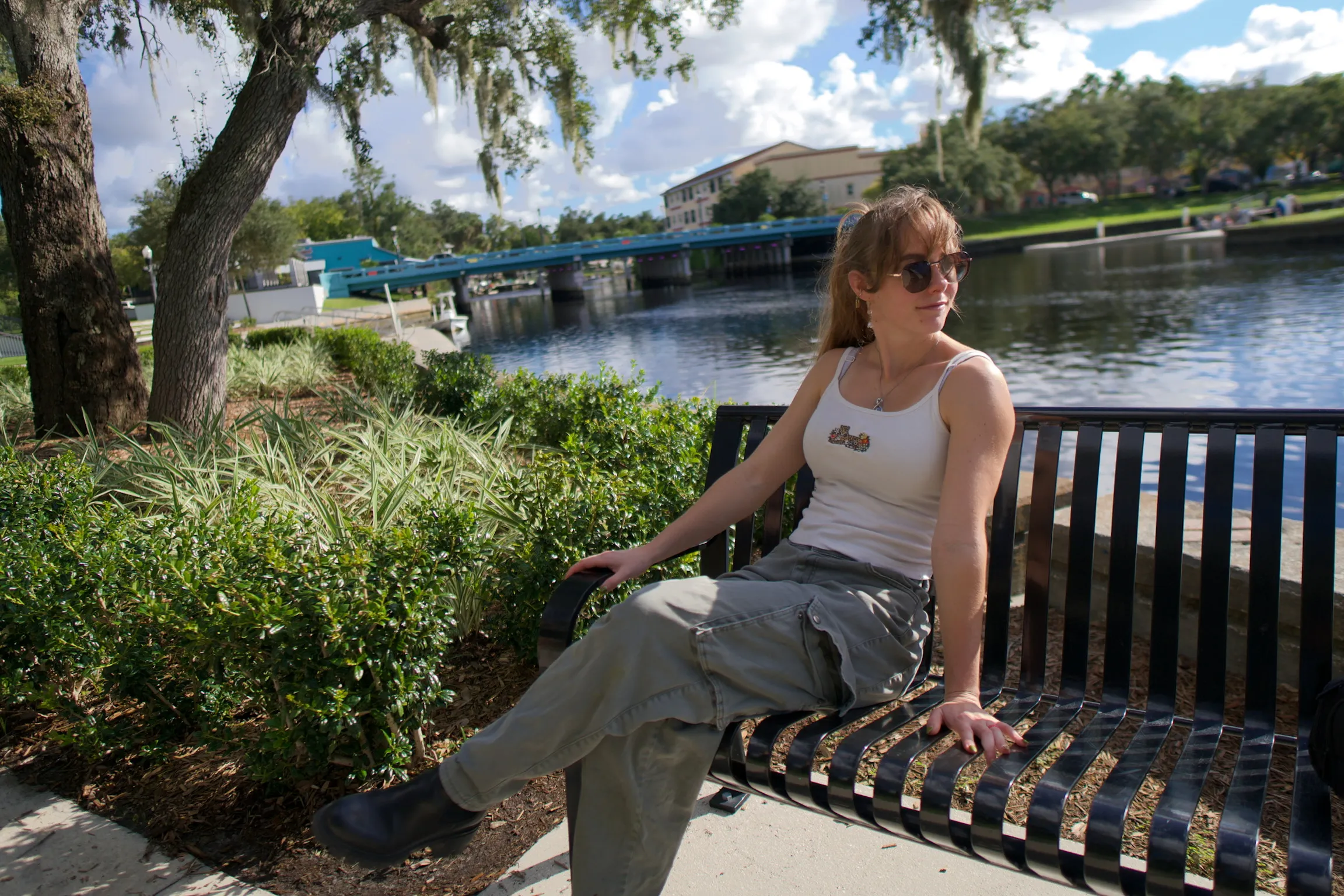 A woman on a bench looking over her shoulder at the water